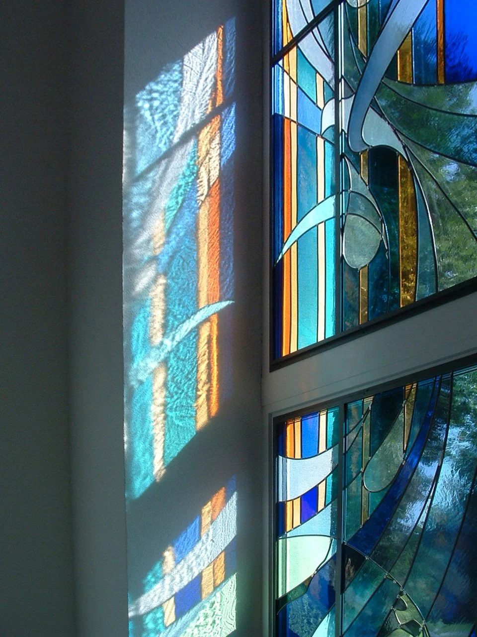 Buntes bemaltes Glasfenster mit Lichtreflexionen an der Wand