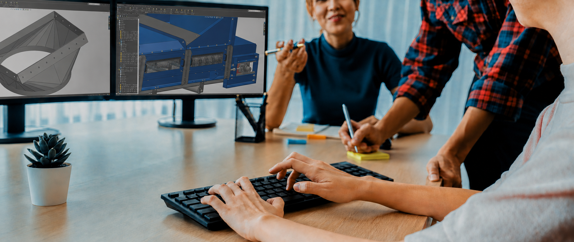 People collaborating on a technical design project and discussing 3D solidworks models.