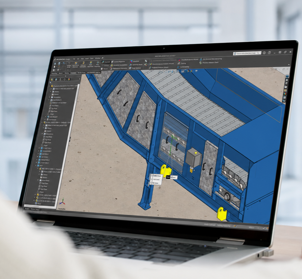 Laptop screen displaying 3D CAD design of machinery or industrial equipment.