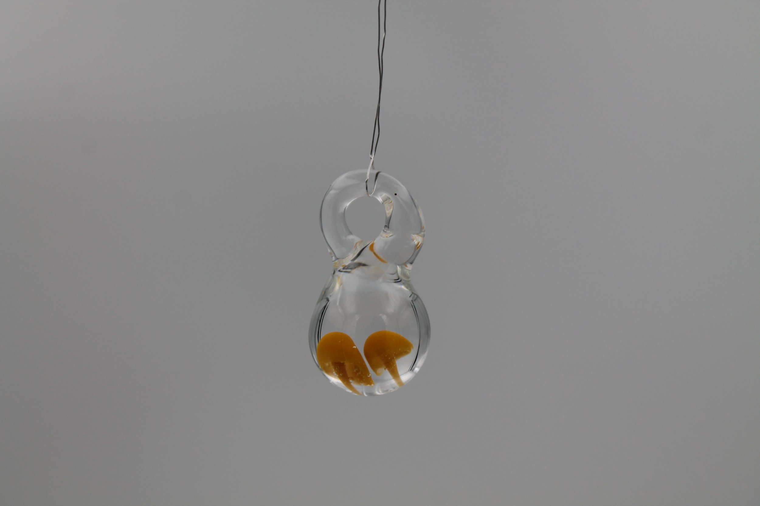 Transparenter handgefertigter Glasanhänger aus Borosilikatglas mit gelben Pilzen