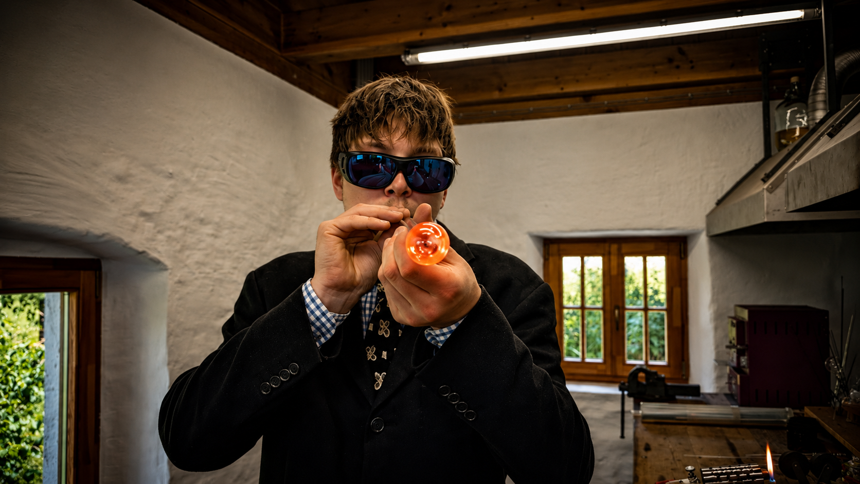 Joshua Beck von Studio Joshi beim Glasblasen mit glühendem Borosilikatglas in seiner Werkstatt