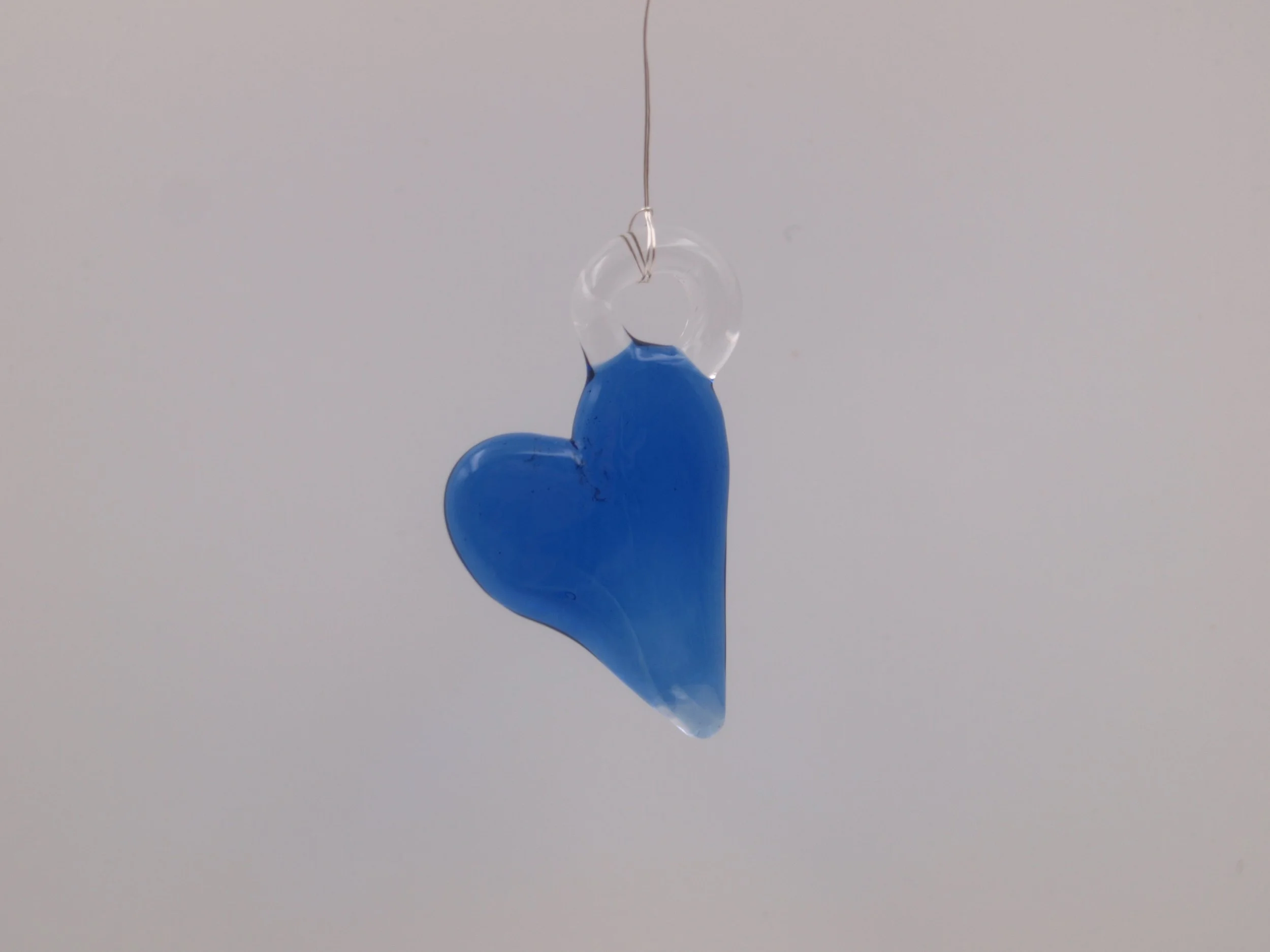 Handgefertigter Herzanhänger aus blauem Borosilikatglas mit transparenter Aufhängung