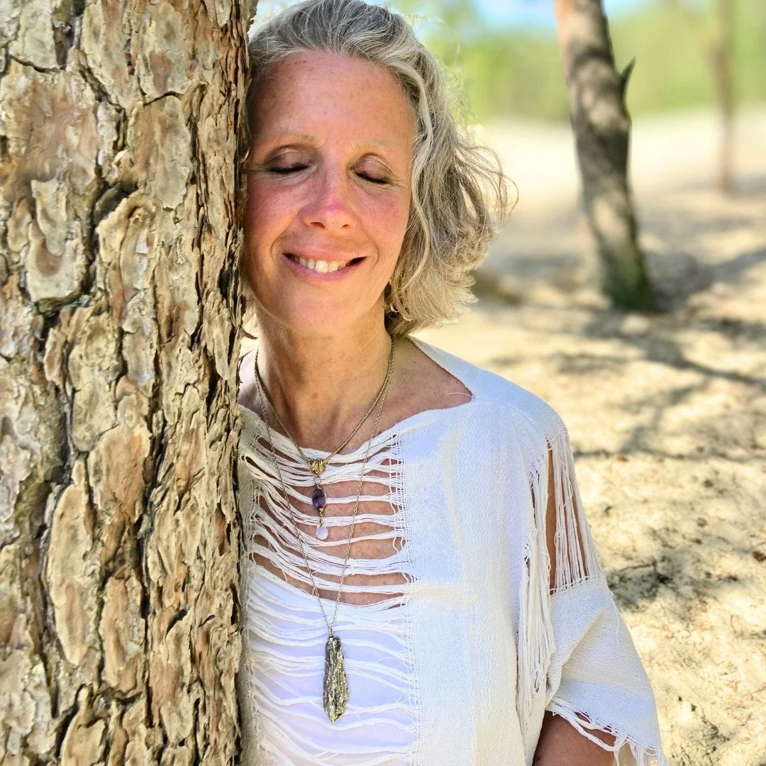 Evie in meditation against a tree