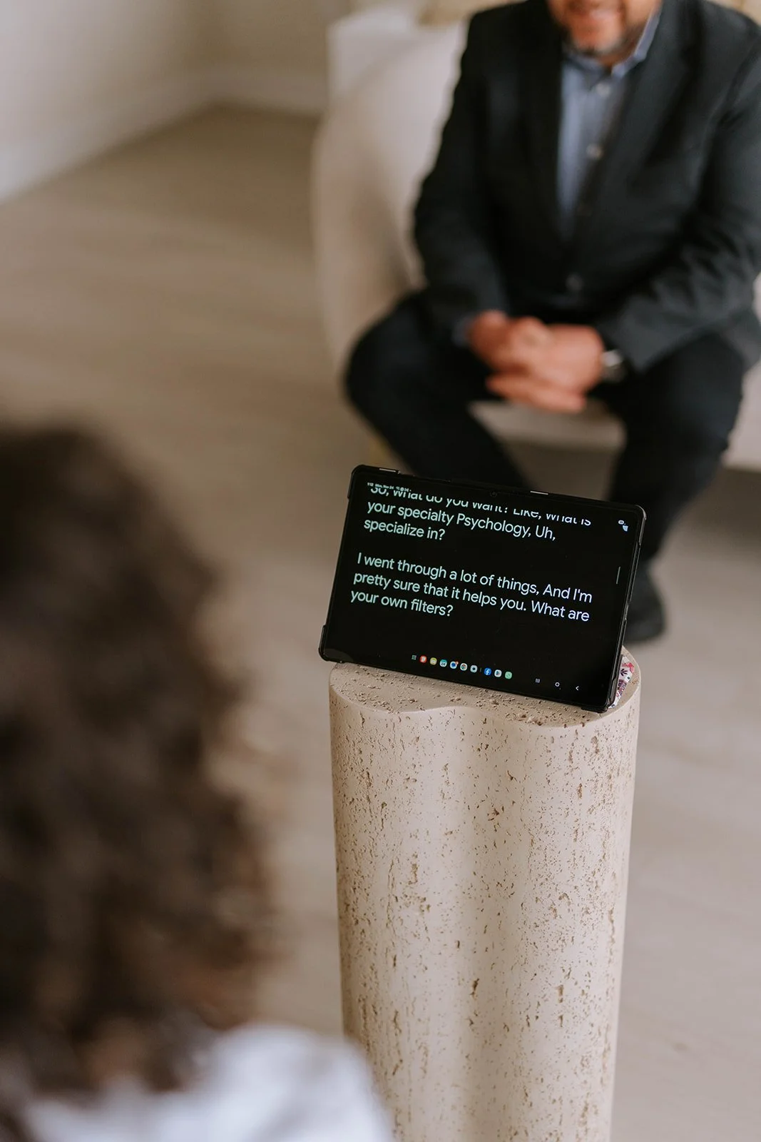 Google Live Transcribe displaying a real-time conversation during a meeting, illustrating the accessibility technology used by Marie-Claire McKelvey.