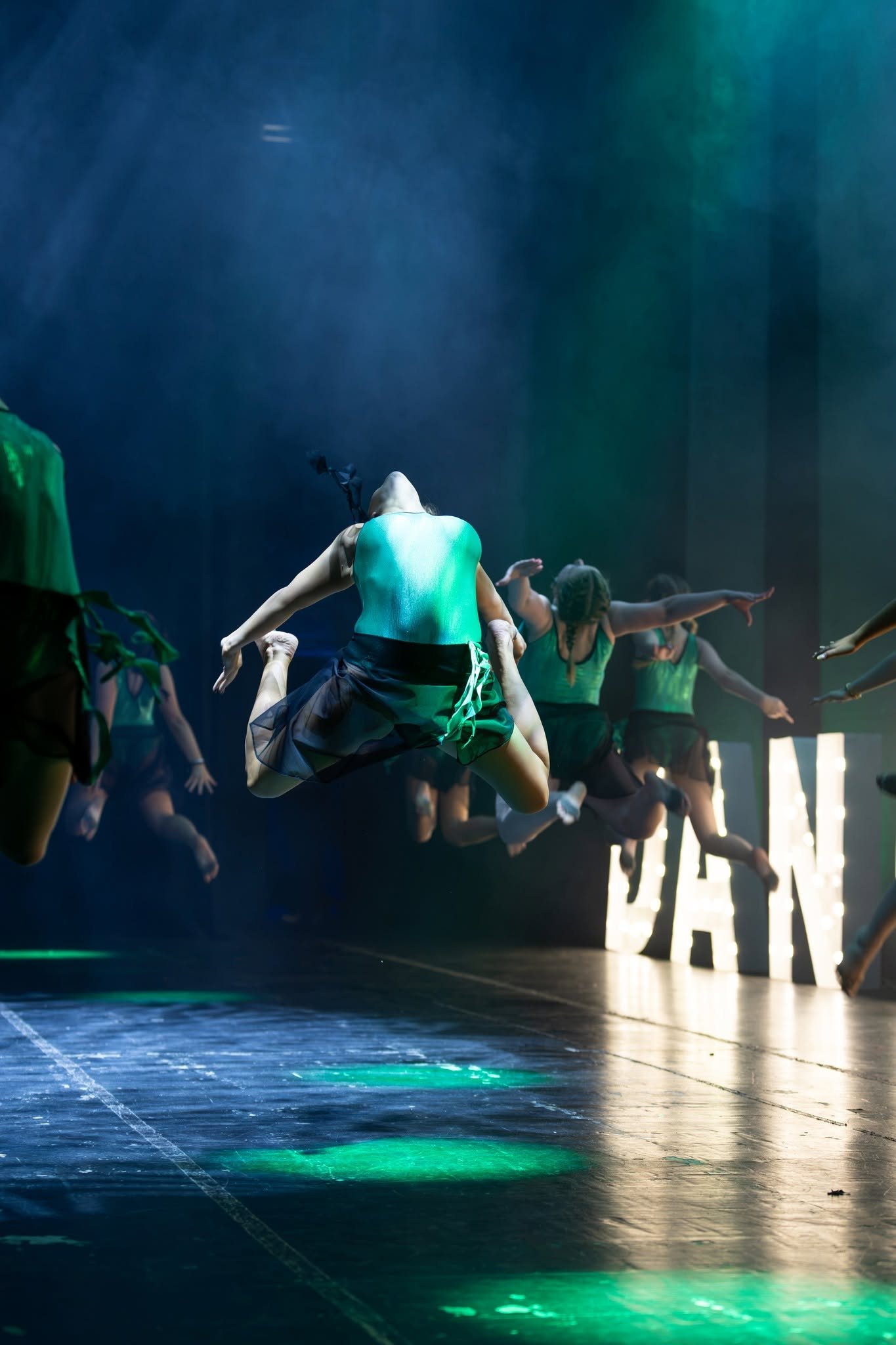 A group of young girls dressed in red and blue costumes performing a dance on stage.