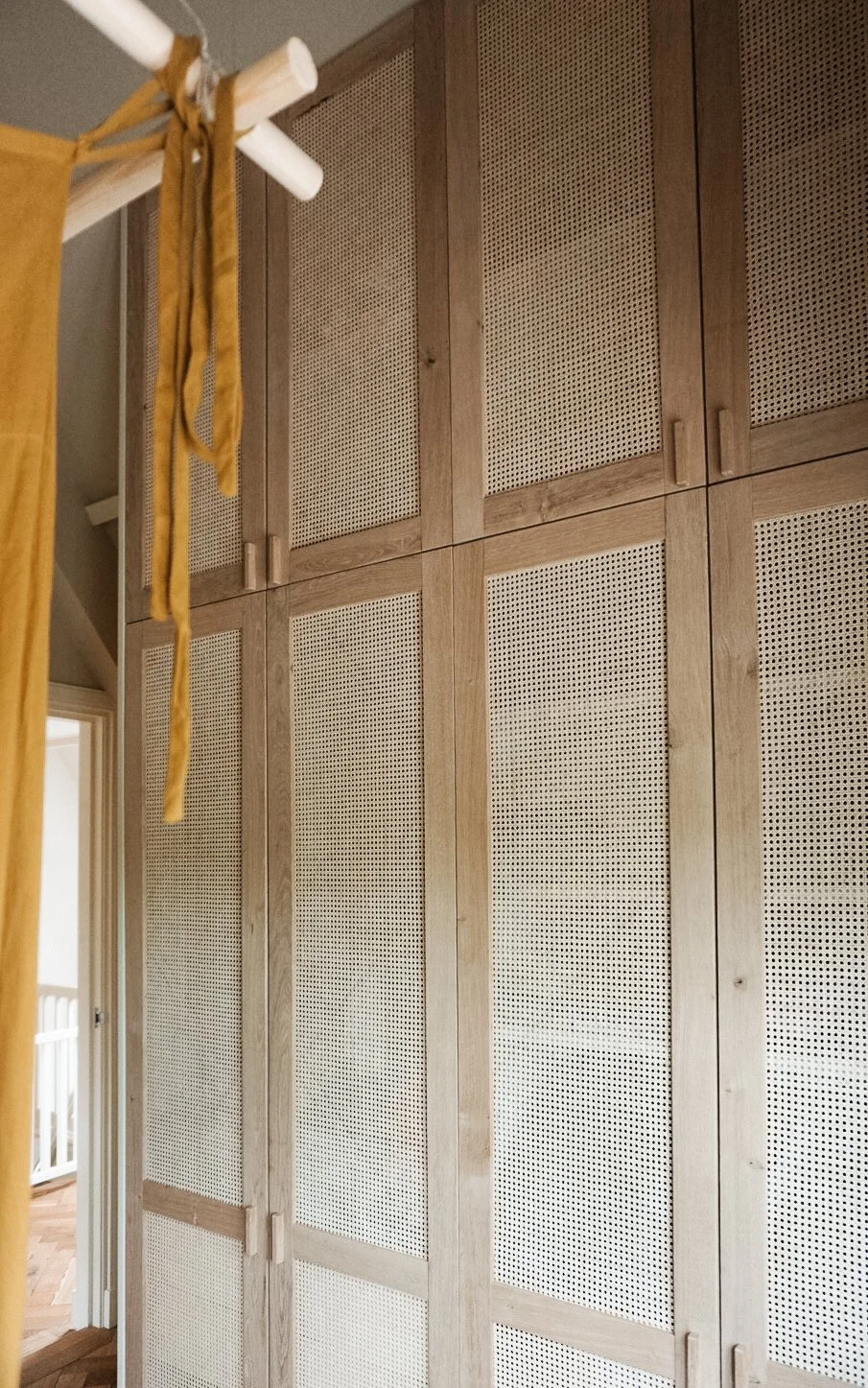 Houten wandkast met geperforeerde panelen in een kamer.