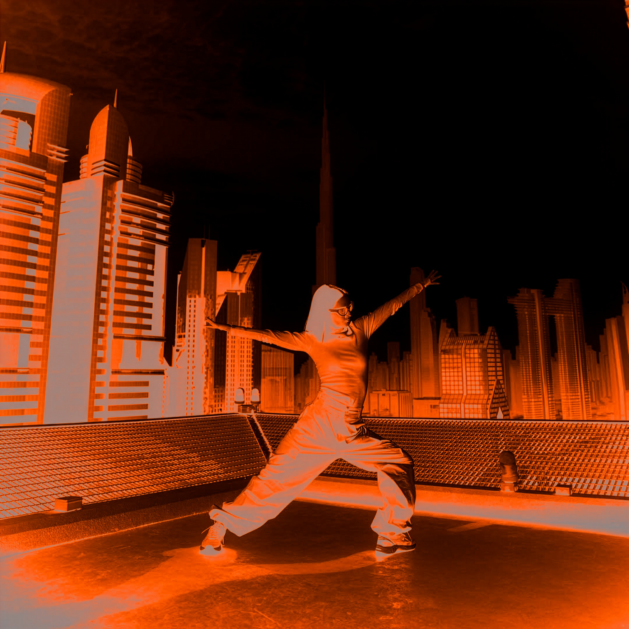 A person performing a dance move on a rooftop at night, with a city skyline featuring tall buildings and skyscrapers illuminated in the background.