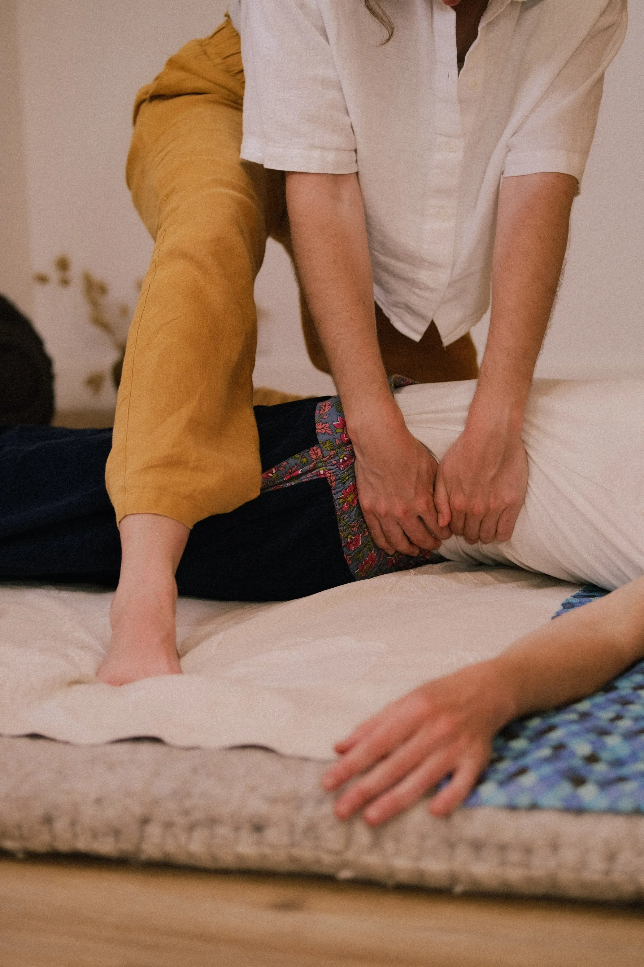 Groupe de personnes faisant une séance de relaxation ou de yoga sur un lit, en position de chien tête en bas.