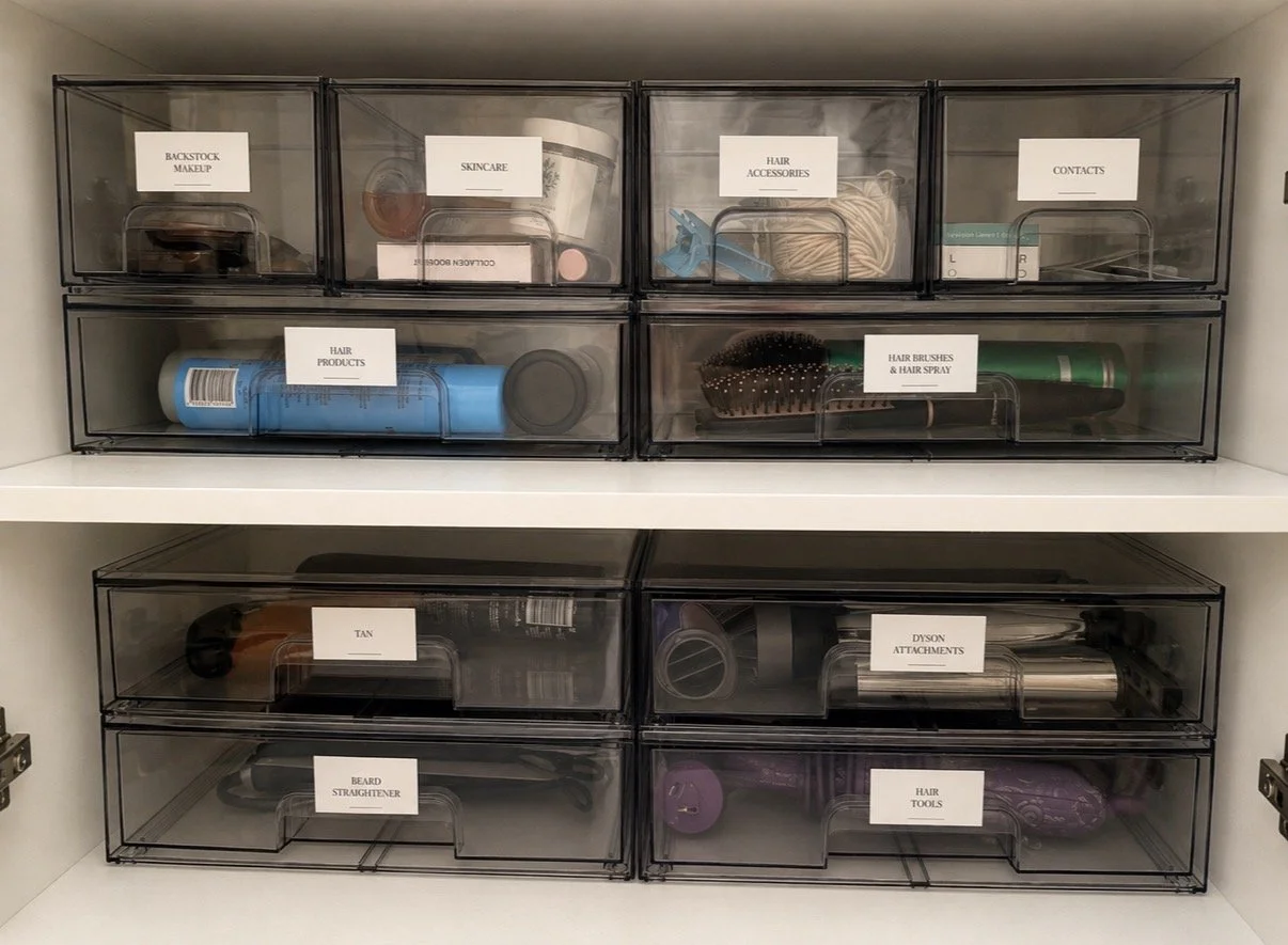 Labelled smoke-grey drawers storing skincare and hair products