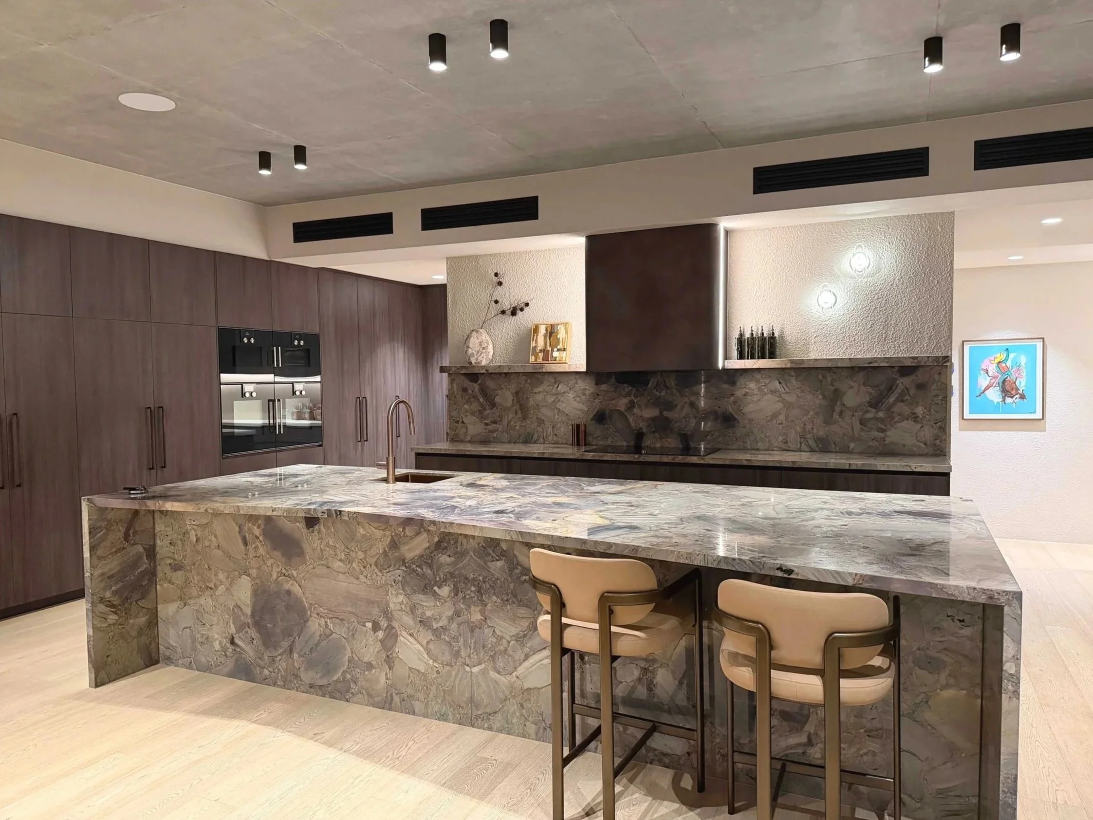Dark timber kitchen with a marble island at the Stella Place project