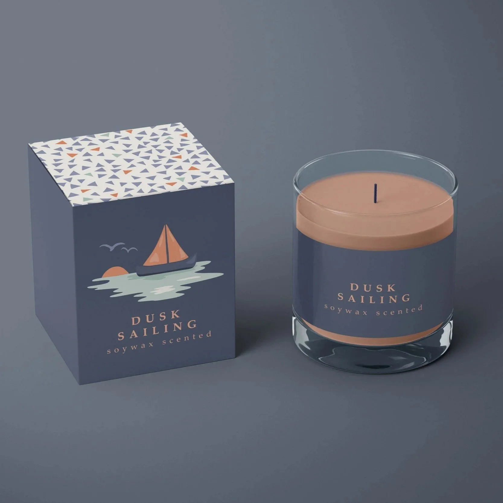 Home fragrance packaging with coordinated nautical pattern designs applied to candle boxes and containers.
