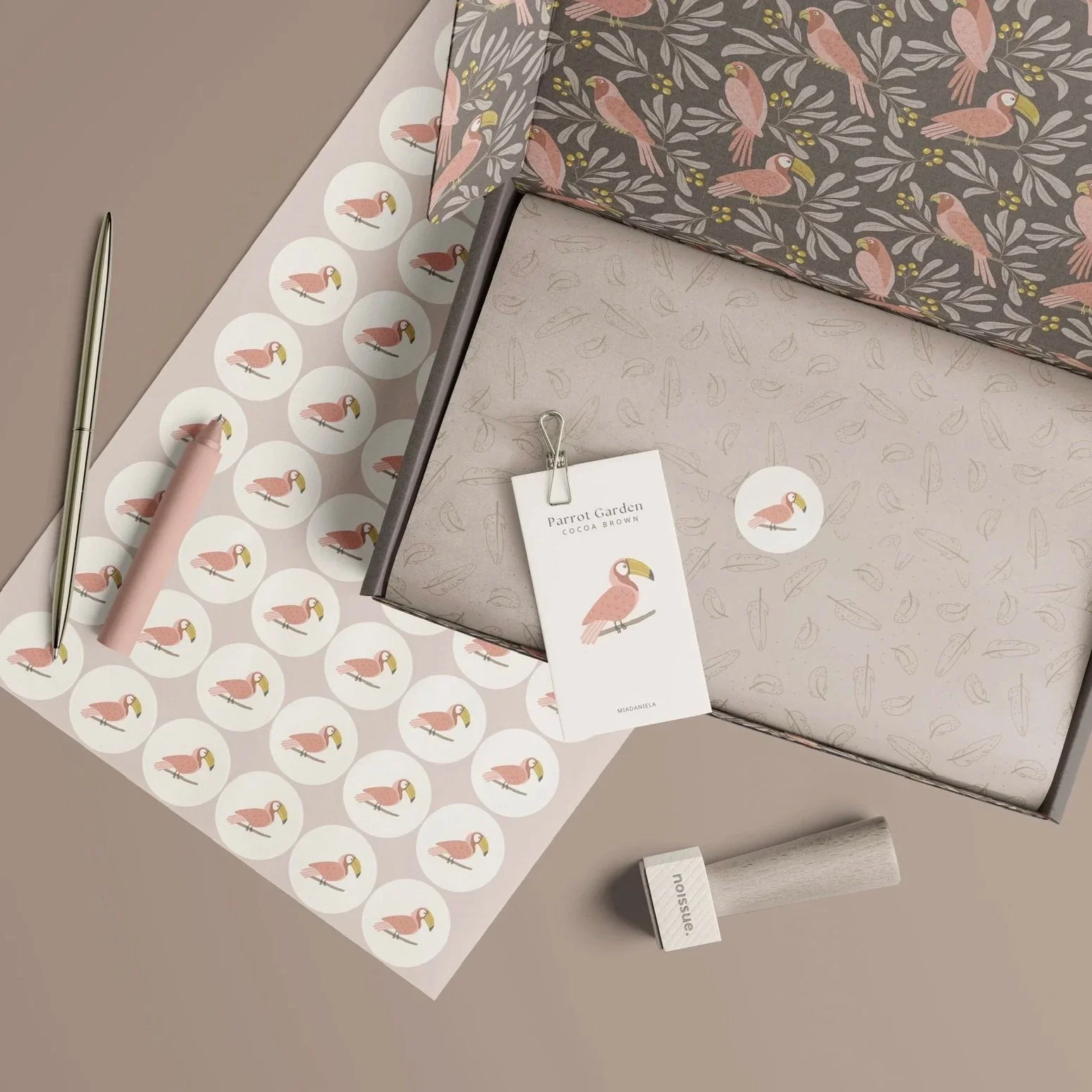 Boutique packaging mockup featuring the Parrot Garden collection in the Cocoa Brown colorway applied to premium gift packaging and paper goods.