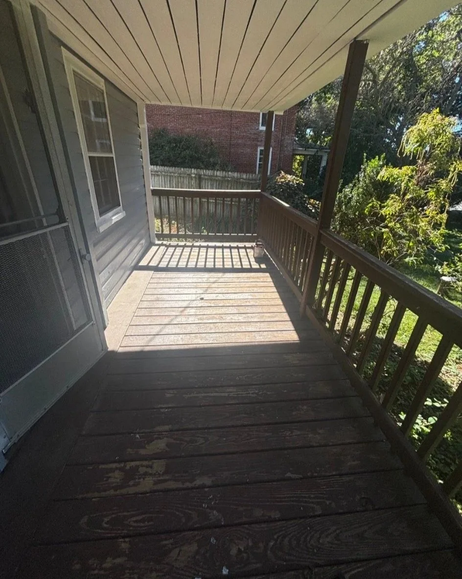 Before: worn finish on the covered porch floor, posts and railings.