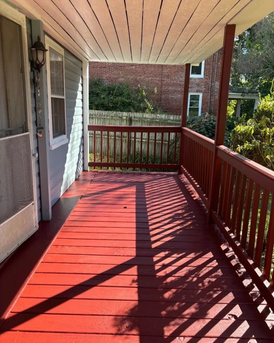 After: rich red porch floor, posts and railings alongside blue-gray siding and a light porch ceiling.