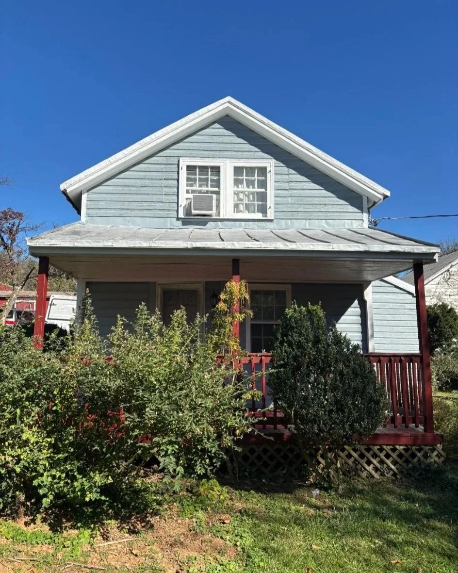 After: refreshed blue-gray front gable, white trim and red porch finishes by Maryland Premier Renovations.