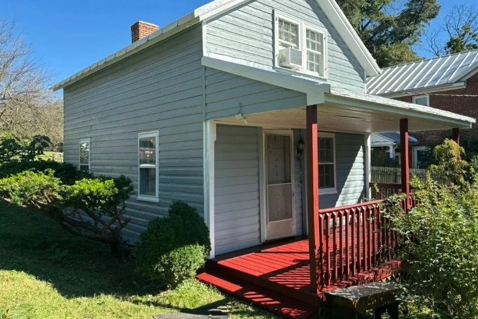 After: blue-gray siding, white trim and a red porch create a refreshed front entry.