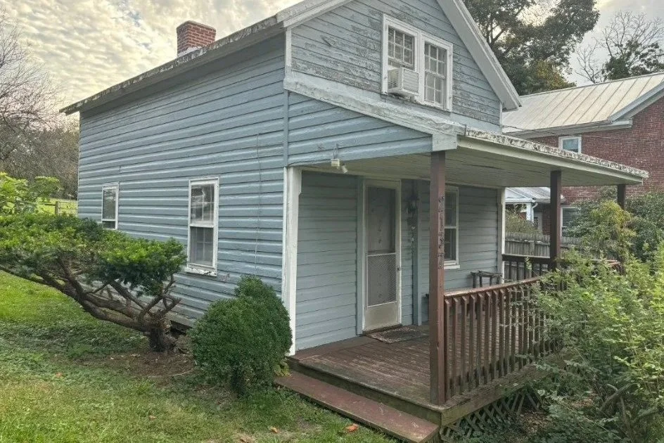 Before: weathered siding, trim and porch finishes at the front entry.