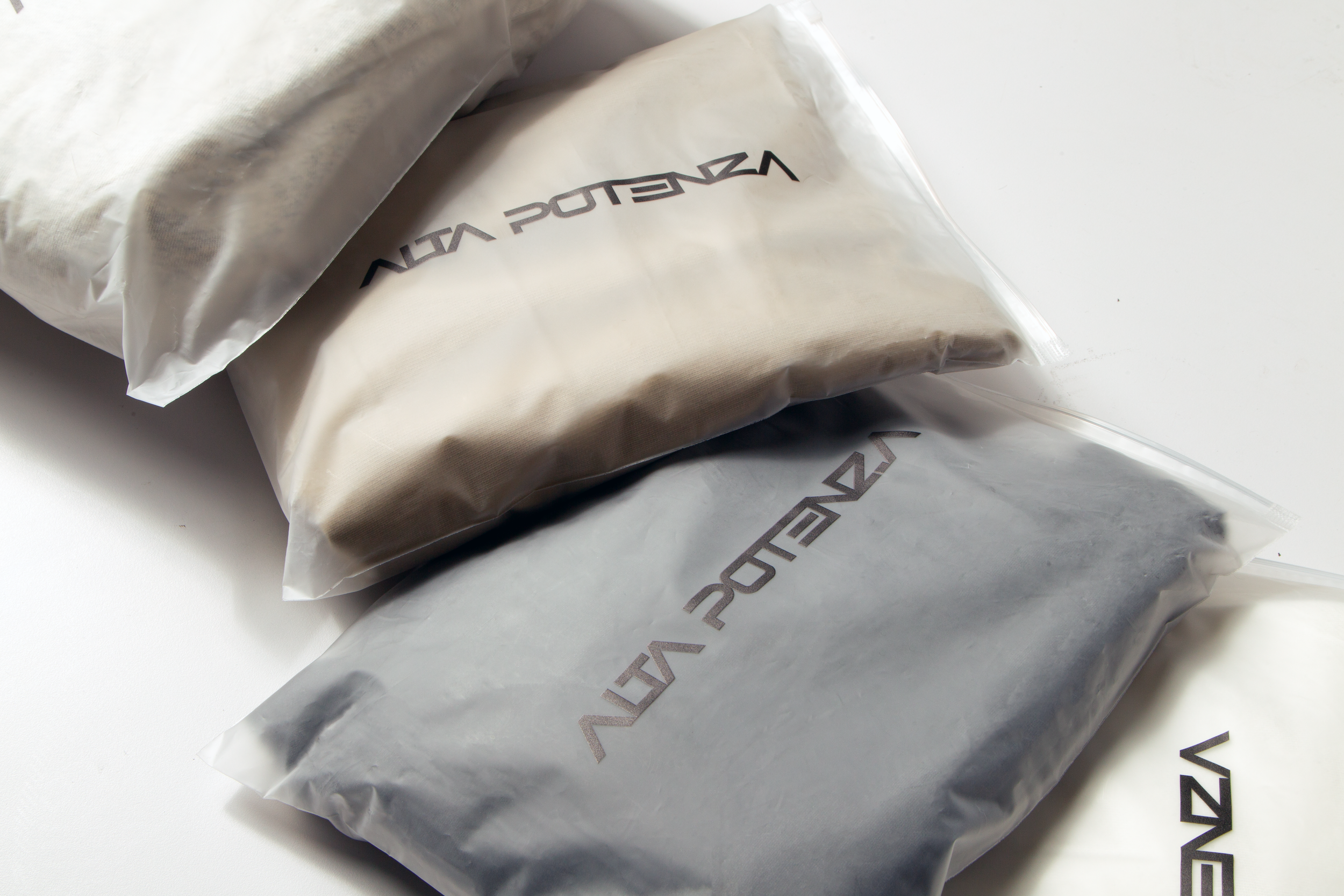Silver metallic bags with black text, likely packaging for a product, on a white surface.