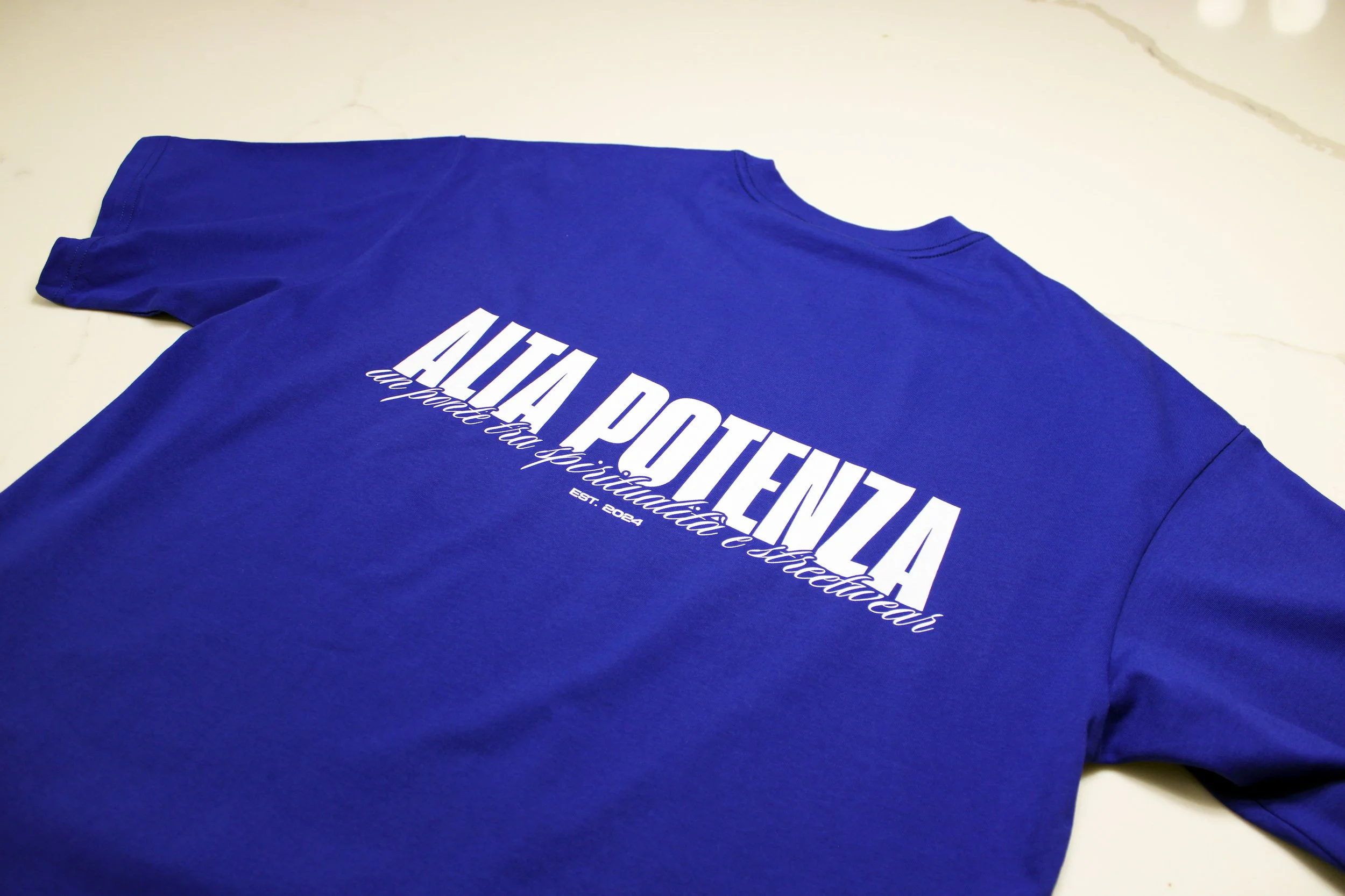 Blue t-shirt with white text reading 'ATTENTION' and smaller text underneath.
