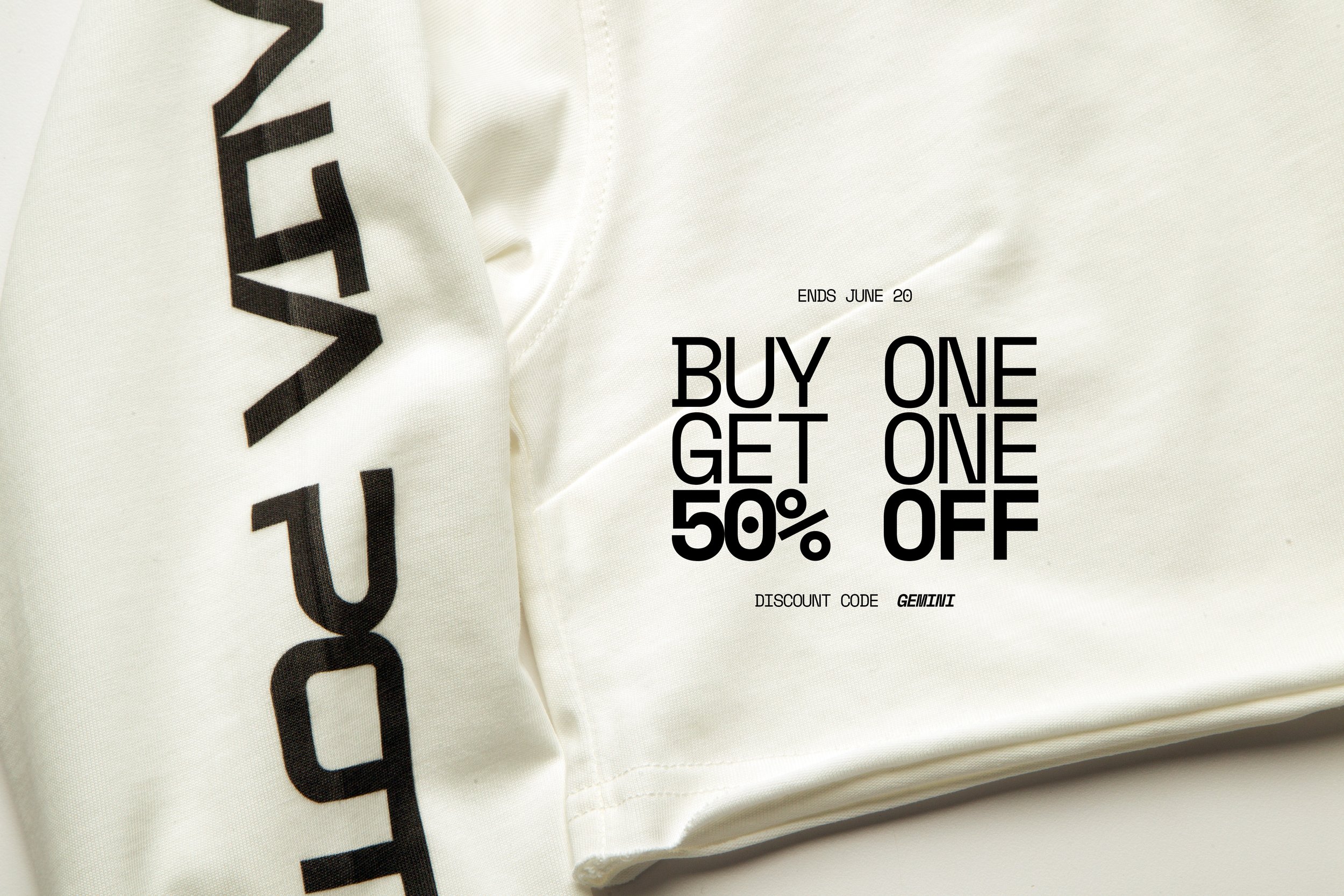 Close-up of a white fabric with black text and promotional offer printed on it, advertising a buy one get one 50% off sale, ending June 20, with a discount code GEMINI.