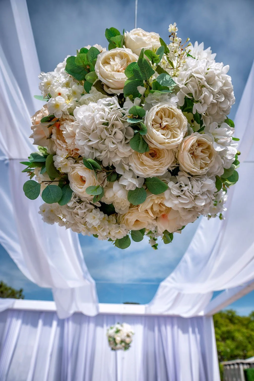 wedding-ceremony-floral-pomander-roses-blue-sky.jpg