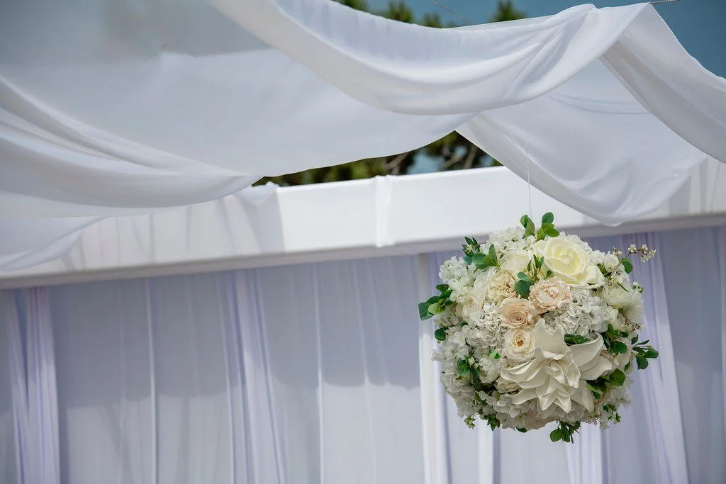 wedding-ceremony-hanging-pomander-white-drape-sky.jpg