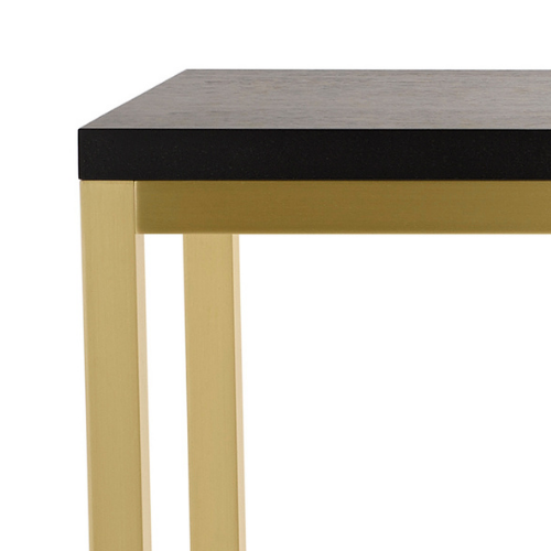 Close-up of a table with a light yellow frame, black and gray top surface, and a plain white background.