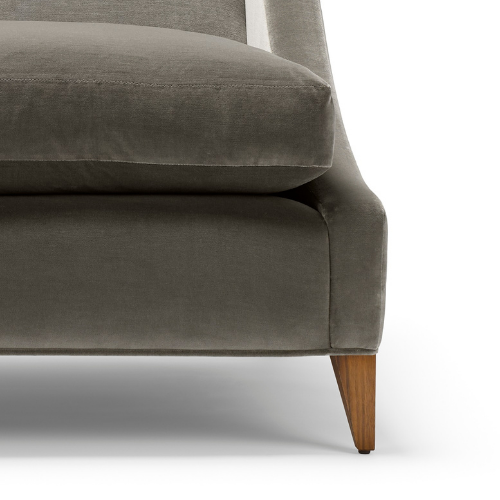 Close-up of a modern gray upholstered sofa with wooden legs against a white background.