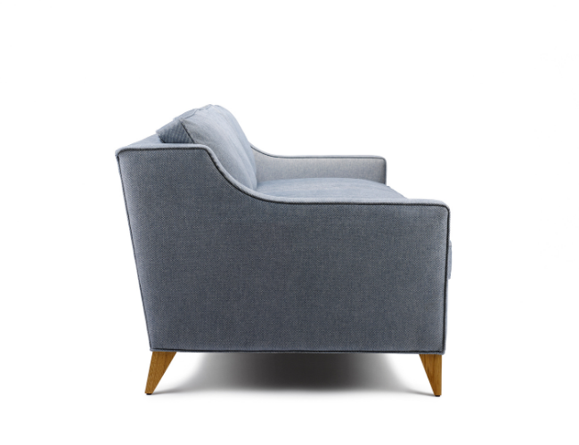 Side view of a light blue upholstered sofa with wooden legs against a white background.