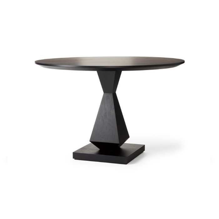A modern black and dark brown round dining table with a geometric pedestal base.
