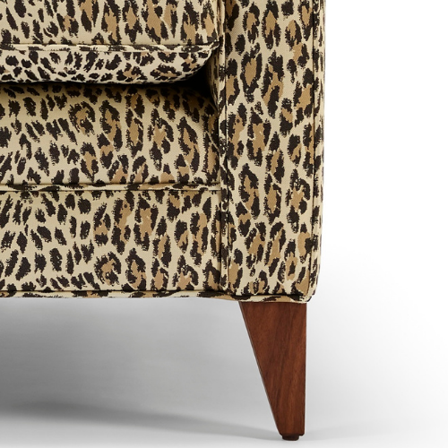 Close up of The Reposer Chair, showing the legs and detailing with leopard print fabric