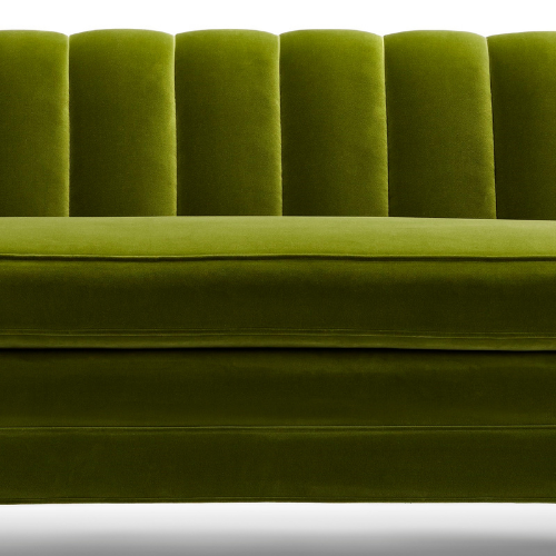 Close-up of a green velvet sofa with vertical tufted cushions.