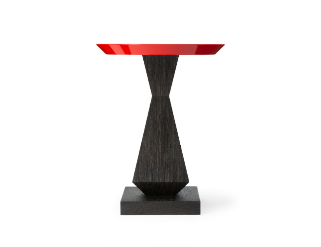 Black wooden pedestal table with a red circular top against a white background.