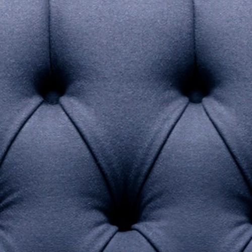 Close-up of dark blue upholstered tufted furniture with button-tufted design.