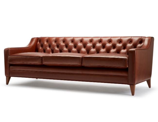 Brown leather tufted sofa with wooden legs.