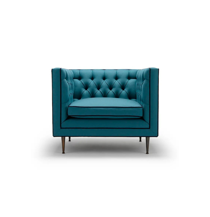 A modern blue upholstered armchair with deep buttoning and wooden legs.