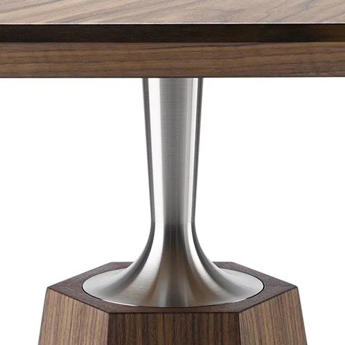 Close-up of a modern table leg with a metal support column on a wooden table and a wooden base.