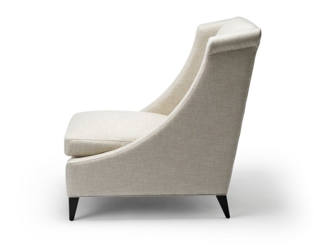 Cream-colored upholstered armchair with angled back and black tapered legs.