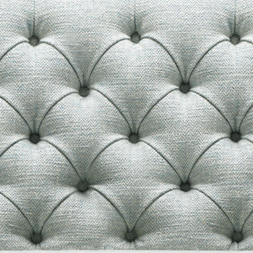 Close-up of a tufted fabric upholstery with diamond-shaped pattern and buttons