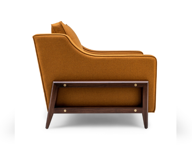 Side view of a vintage orange sofa with a wooden frame and tapered legs on a white background.