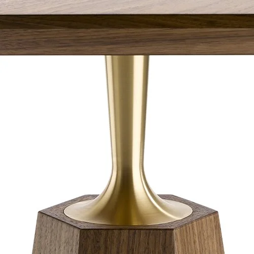 Close-up of a table leg with a gold-colored, flared metallic support on a wooden base.