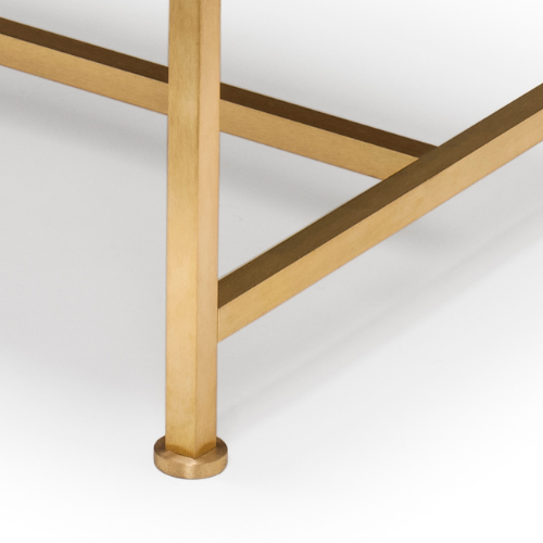 Close-up of a wooden table leg with a circular base, part of a table with a white top and wooden support beams.