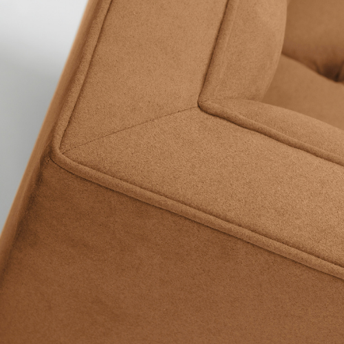 Close-up of a tan upholstered sofa with seam details.