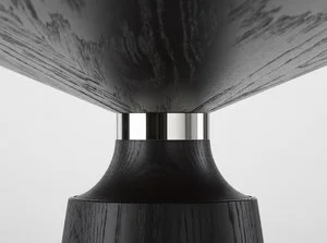 A close-up of a modern black table with a round base and a black tabletop.