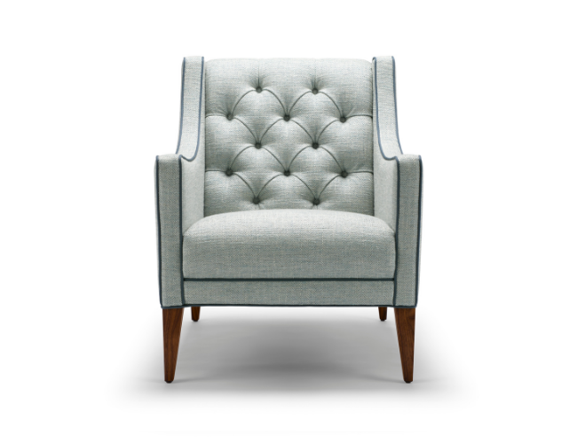 A light gray upholstered armchair with tufted backrest and wooden legs.