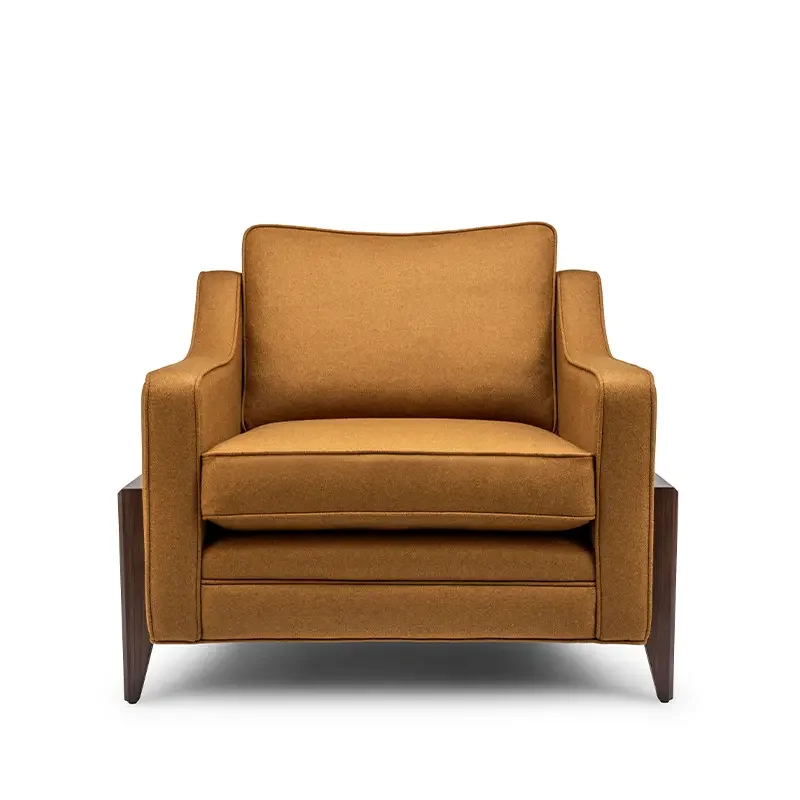 A mustard-colored armchair with wooden legs, set against a plain white background.