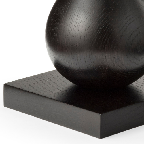 Close-up of a black, spherical sculpture on a square black pedestal.