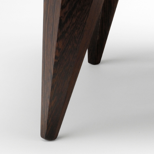Close-up of a dark wooden furniture leg against a white background.