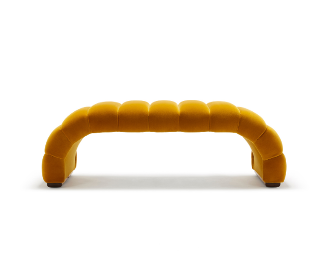 A modern yellow upholstered bench with a curved design against a white background.