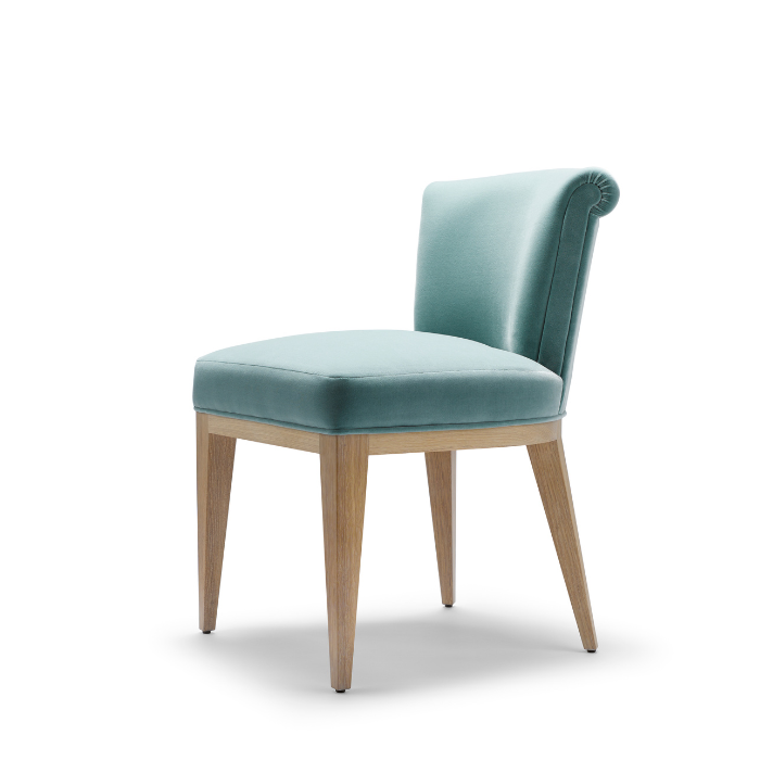 Light blue upholstered chair with wooden legs and a tufted backrest
